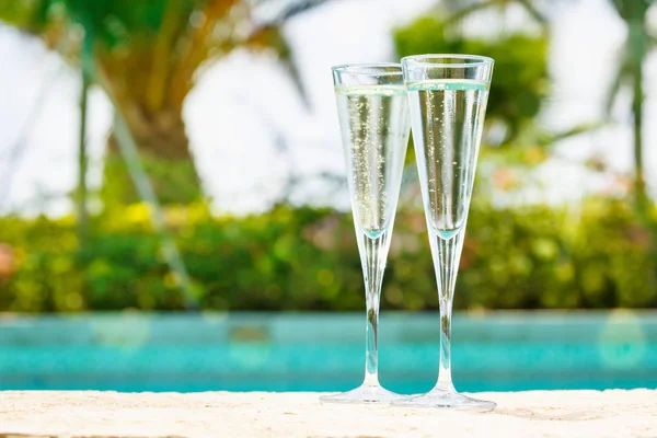 Due bicchieri di prosecco ai bordi di una piscina del resort. Concetto — Foto Stock