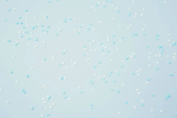 White and blue snowflakes sprinkles on blue. Festive holiday bac — Stock Photo, Image