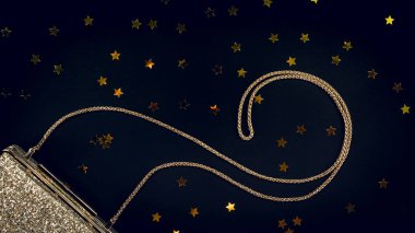 Siyah yıldız sprinkles ile şenlikli akşam altın Debriyaj. Holi