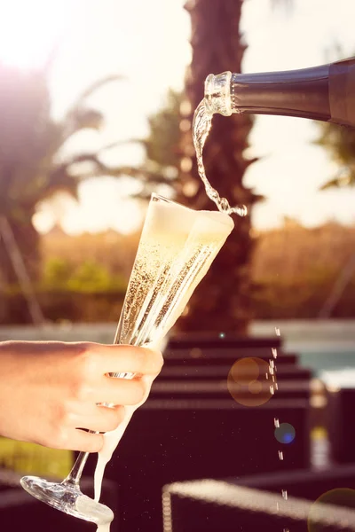 Kyparen är pourring mousserande vin i en kvinna glas på outd — Stockfoto