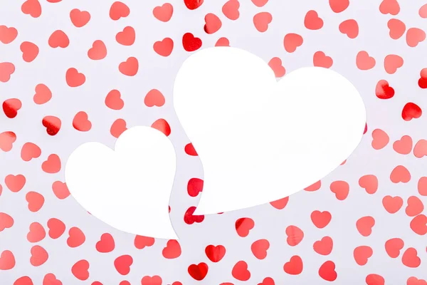 Два білих серця з блискучою серцевою конфетті. День святого Валентина — стокове фото
