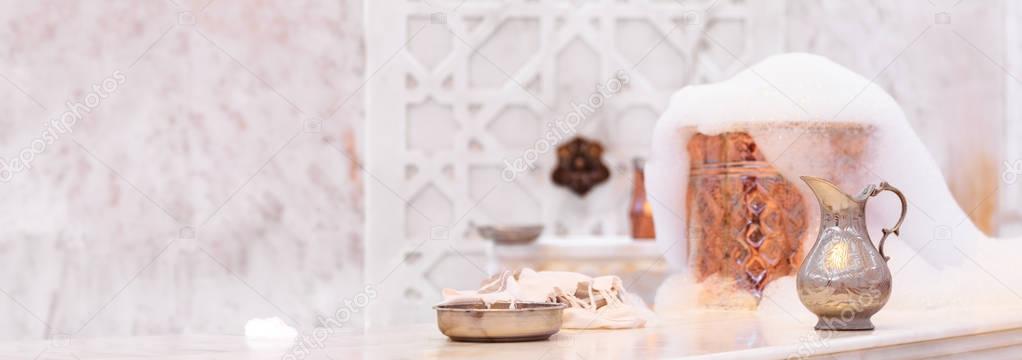 Water jar, towel and copper bowl with soap foam in turkish hamam