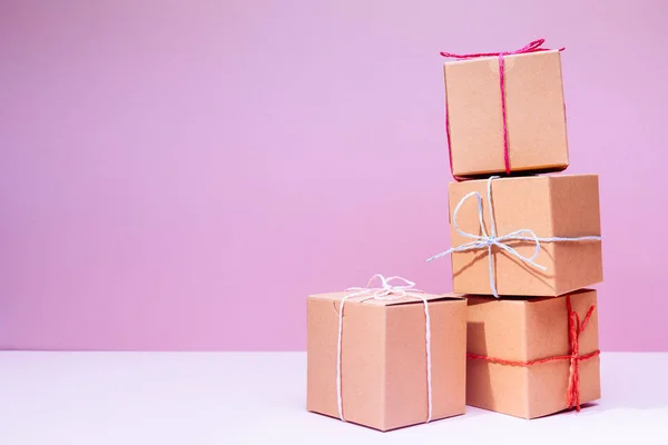 Cajas de regalo de cartón artesanal en el fondo rosa sólido. Vacaciones — Foto de Stock