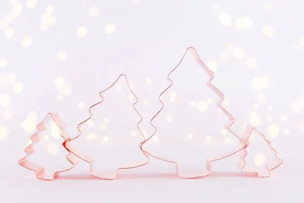 Familia de árbol de Navidad Cortador de galletas de cobre sobre fondo blanco brillante con luces bokeh. Navidad y Año Nuevo fondo de vacaciones — Foto de Stock