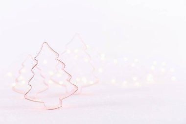 Beyaz ışıltılı arka planda bokeh ışıkları olan çeşitli Noel Ağacı Bakır kurabiye kesicileri. Noel tatili ve yeni yıl geçmişi