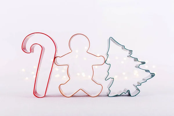 흰색빛나는 배경에 보케등을 달아 놓은 멀티 컬러 쿠키 커터입니다. 크리스마스와 새해의 배경 — 스톡 사진