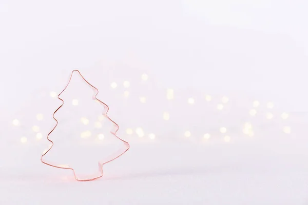 Árbol de Navidad Cortador de galletas de cobre sobre fondo blanco brillante con luces bokeh. Navidad y Año Nuevo fondo de vacaciones — Foto de Stock