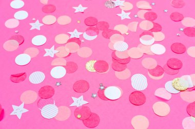 Pembe, altın ve beyaz konfeti koyu pembe arka planda, bayram kutlamaları arka planında