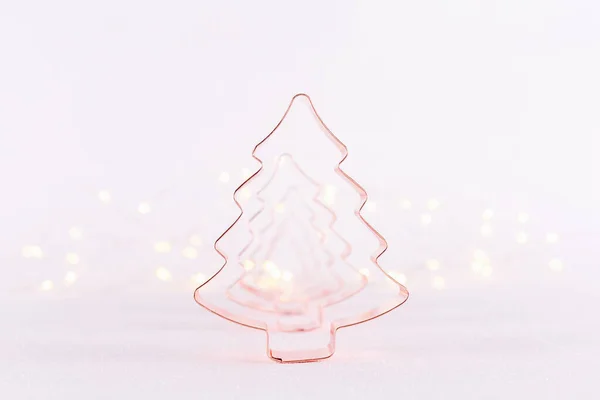 Árbol de Navidad Cortadores de galletas de cobre sobre fondo blanco brillante con luces bokeh. Navidad y Año Nuevo fondo de vacaciones — Foto de Stock
