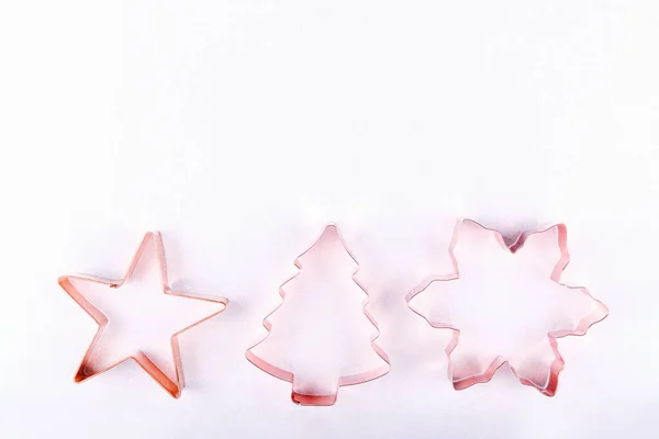 Pisos con estrellas, copos de nieve y cortadores de galletas de cobre árbol de vacaciones sobre fondo blanco brillante. Concepto de vacaciones, Navidad y Año Nuevo. Acogedores detalles hogareños — Foto de Stock