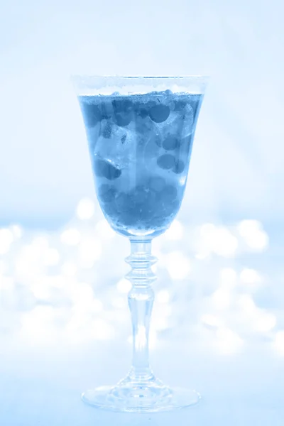 Egy pohár pezsgő és áfonyakoktél. Közelről, kékre festve. — Stock Fotó