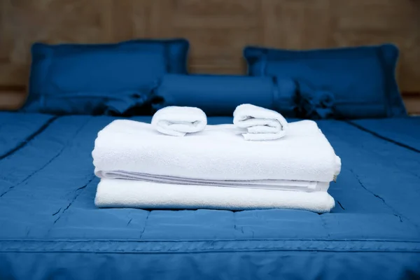 青の寝具とホテルのベッドの上のきれいなタオル — ストック写真