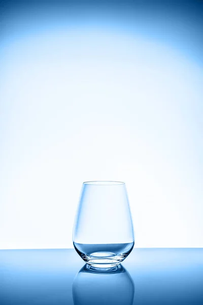 푸른 빛 배경에 있는 현대의 물이나 포도주 잔 — 스톡 사진