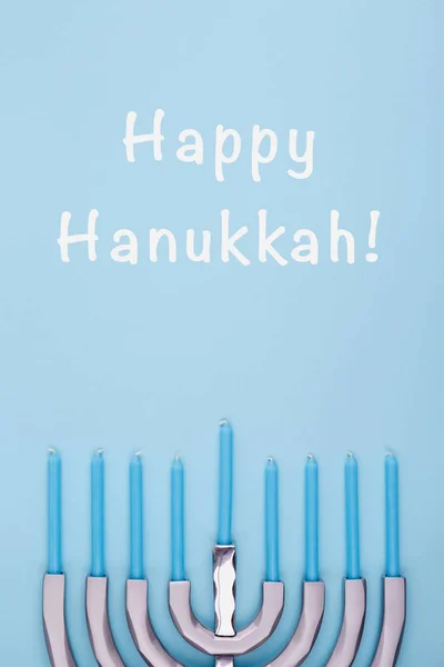 Fondo azul con menora y velas y redacción de Happy Hanukkah. Hanukkah y judaic concepto de vacaciones . — Foto de Stock