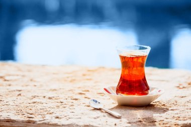Suyun yanında sıcak Türk çayı. Türk çayı ve geleneksel Türk kültürü konsepti klasik mavi tonda