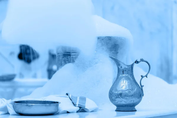 Zeepschuim maken voor massage. Waterpot, handdoek en koperen kom met zeepschuim in turkse hamam. Traditionele interieur details getint in klassiek blauw — Stockfoto