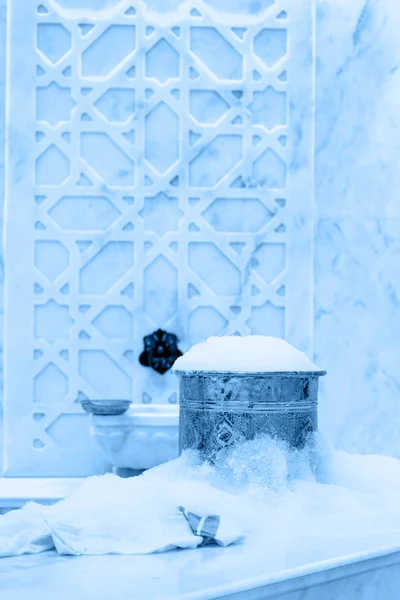 Toalha e tigela de cobre com espuma de sabão em hamam turco. Detalhes interiores tradicionais tonificados em azul clássico — Fotografia de Stock