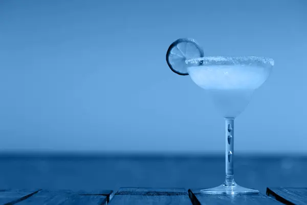 木製の桟橋にマルガリータカクテル。古典的な飲み物の概念。古典的な青で休暇の背景 — ストック写真