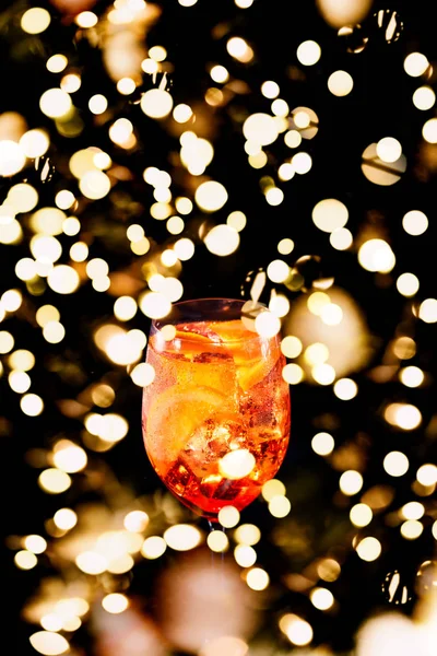 Cocktail de spritz apéro alcoolisé élégant avec tranche d'orange sur fond noir. Place pour votre texte avec des vacances festives bokeh — Photo