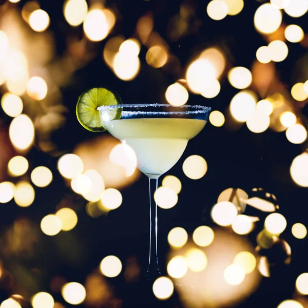 Classic daiquiri on the dark background. Luxury craft drink concept with festive holiday bokeh — Stock Photo, Image