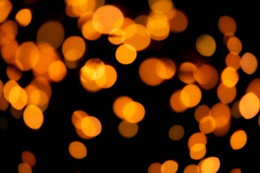 Siyah arka plan ve parlak, sıcak bokeh ışıkları. Tatil, Noel ve Yeni Yıl geçmişi. Herhangi bir tasarım için ideal