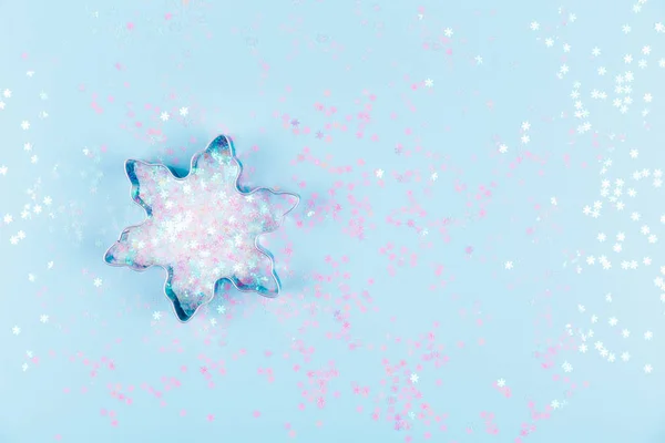 Aplanado con cortador de galletas de copo de nieve y aspersiones de copo de nieve sobre fondo azul. Concepto de vacaciones, Navidad y Año Nuevo. Acogedores detalles hogareños — Foto de Stock