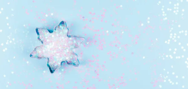 Flatlay com cortador de biscoito floco de neve e salpicos de floco de neve no fundo azul. Férias, Natal e Ano Novo conceito. Detalhes acolhedores e acolhedores — Fotografia de Stock