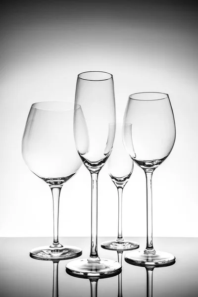 Selección de cristalería con copas de vino, champán y licor sobre fondo claro — Foto de Stock