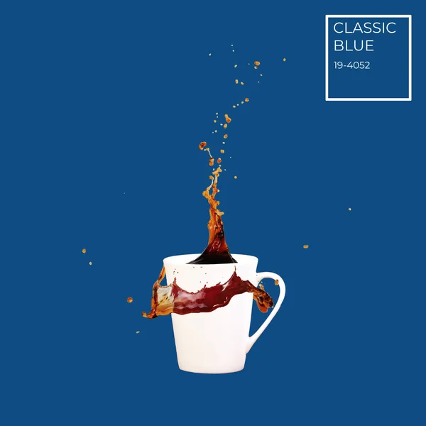 Schwebender Kaffeebecher mit Spritzern auf solidem, klassisch blauem Hintergrund. Kaffee-Konzept. Minimal Art Trend. mit farbigem Namensschild — Stockfoto