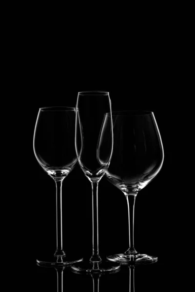 Üvegáruk választéka borral, pezsgővel és likőrpoharakkal a sötét háttérben — Stock Fotó