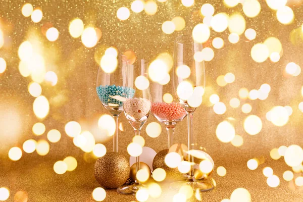 Gafas con chispas y juguetes sobre el festivo fondo dorado. Concepto de fiesta de Navidad y Año Nuevo. Elegante temporada de vacaciones de moda con luces bokeh festivas —  Fotos de Stock