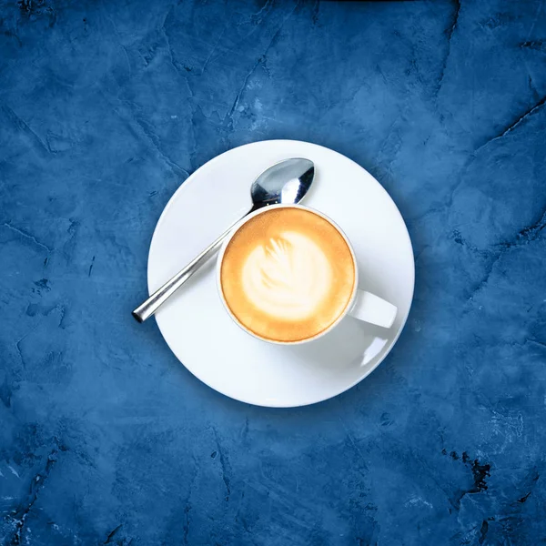 Bir fincan kahve, latte sanatıyla mermer arka planda mavi tonda. — Stok fotoğraf