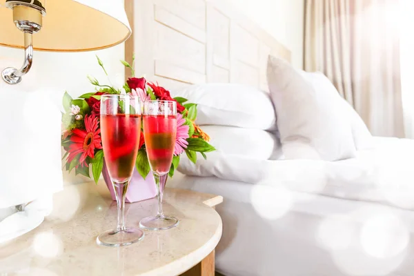 Deux verres de champagne rose avec bokeh festif léger dans la chambre d'hôtel haut de gamme. Rencontres, romance, lune de miel, Saint Valentin, escapade, séjour, concepts de désintoxication numérique — Photo