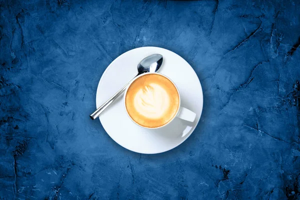 Bir fincan kahve, latte sanatıyla mermer arka planda mavi tonda. — Stok fotoğraf