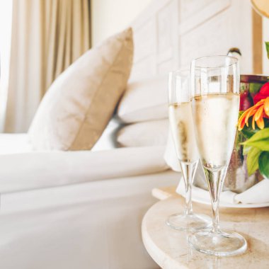 Lüks otel odasında iki bardak şampanya. Çıkma, romantizm, balayı, sevgililer günü, kaçamak kavramları
