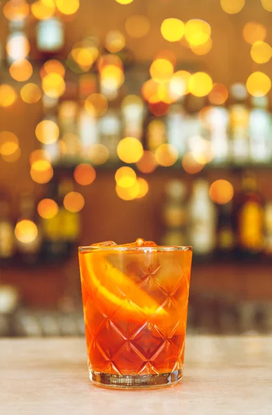 Склянка смачного алкогольного негритянського коктейлю з апельсиновим скибочкою знаходиться на барній стійці . — стокове фото