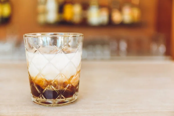 Glass av velsmakende, alkoholholdig svart og hvit, russisk cocktail på bardisken . – stockfoto