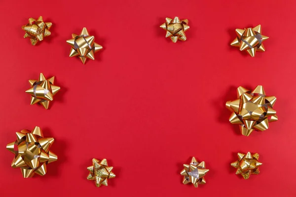 Golden gift bows on the red background with place for text — 스톡 사진