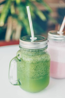 Lüks spor salonlarında veya vejetaryen kafelerde kağıt kamışlı çevre dostu cam kavanozlarda sağlıklı smoothie seçenekleri