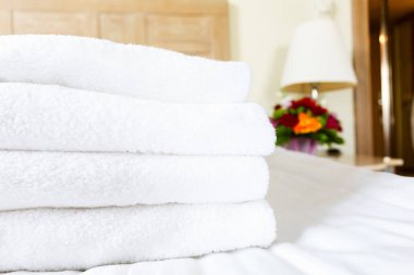 Lüks otel odasında taze beyaz havlu yığını. Yalnız olmak, kaçmak, kalmak, dijital detoks, gezi, tatil kavramları.