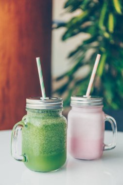 Lüks spor salonlarında veya vejetaryen kafelerde kağıt kamışlı çevre dostu cam kavanozlarda sağlıklı smoothie seçenekleri