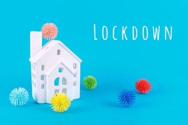 Niedliches Häuschen und Plastikbälle aka Viren auf blauem Hintergrund mit Lockdown-Schriftzug. Epidemie, soziale Isolation, Coronavirus COVID-19-Konzept — Stockfoto