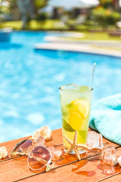 Glas med klassisk mojito cocktail med skal, solglasögon och handduk. — Stockfoto