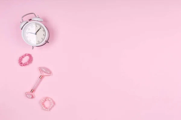 Нефритовый ролик с белыми часами и розовыми аксессуарами — стоковое фото