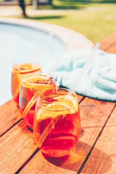 Three glasses of aperol spritz and negroni cold cocktail near pool — Stock Photo, Image