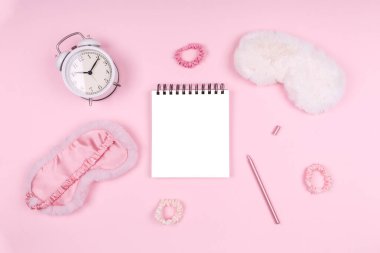 Şirin kabarık uyku maskeleri ve pembe aksesuarları olan not defteri.