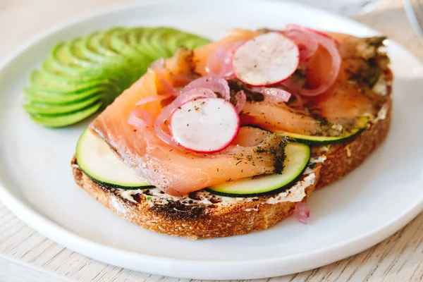 Salmon toast with avocado and vegs in the modern cafe — Stock Photo, Image