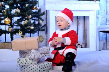 Çocuk Noel Baba hediyeleri ile giyinmiş.