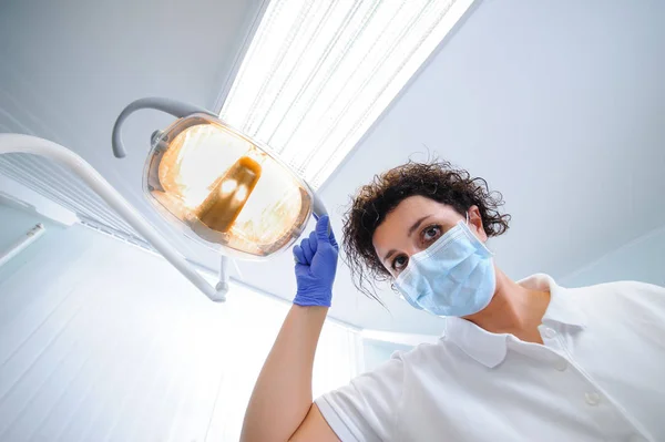 Retrato de dentista con máscara quirúrgica mientras sostiene l dental — Foto de Stock