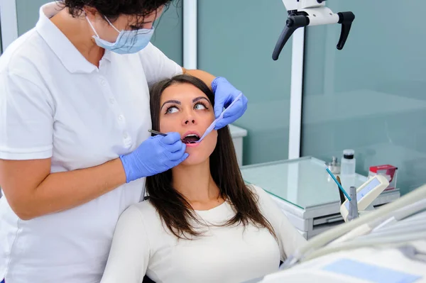 Mujer dentista trabajando en los dientes de sus pacientes — Foto de Stock